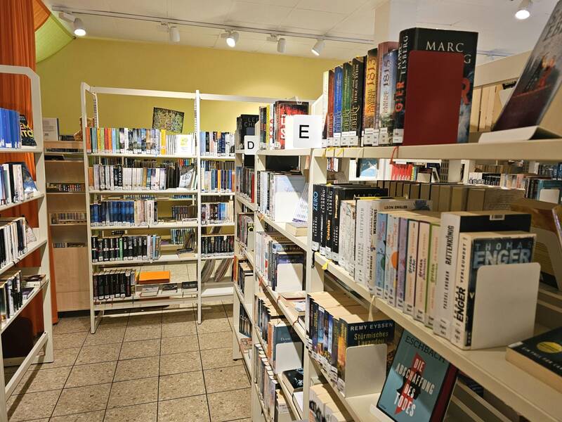 Ein Raum mit mehreren Bücherregalen, die dicht mit Büchern gefüllt sind.