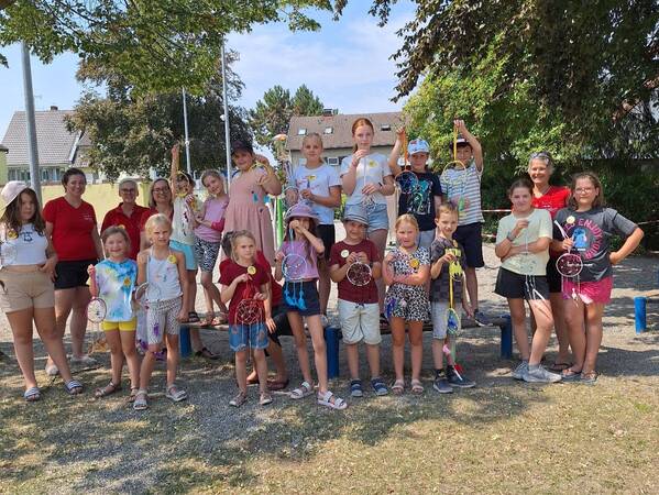 Traumfänger - Eine Gruppe von Kindern und Erwachsenen posiert fröhlich im Freien und hält selbstgemachte Traumfänger.