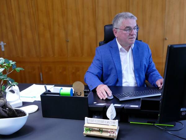 Bürgermeister Ralf Baumert sitzt am Schreibtisch und schaut konzentriert auf den Computerbildschirm.