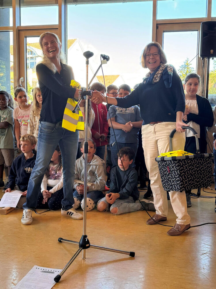 Franziska Nöthen, Schulleiterin der Scheffelschule, freut sich über die Warnwesten für die Schulanfänger, überreicht von Silke Regitz (Vorstandsmitglied PRO|RIWO).